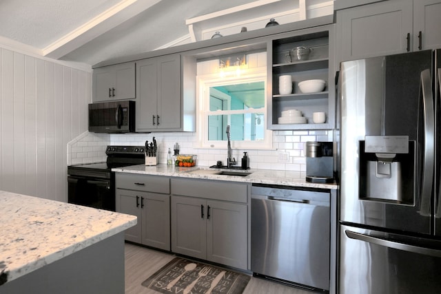 kitchen featuring gray cabinets, appliances with stainless steel finishes, decorative backsplash, and a sink