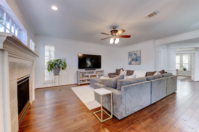 15122 Windsdowne Ln, Cypress, TX 77429 - living area featuring a fireplace, wood finished floors, ceiling fan, ornamental molding, and plenty of natural light