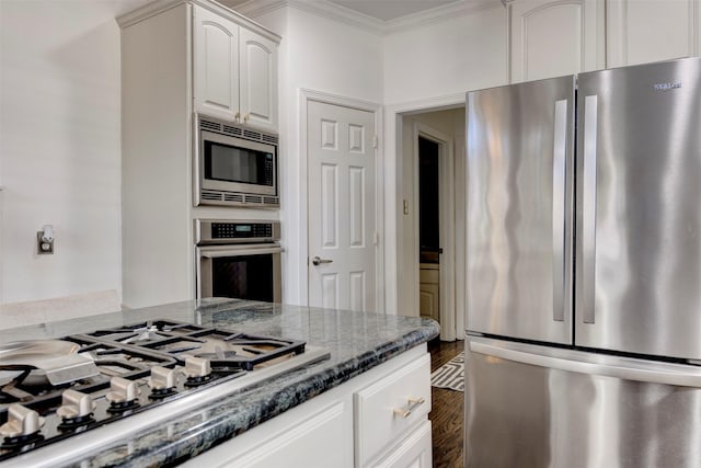 15122 Windsdowne Ln, Cypress, TX 77429 - kitchen with stainless steel appliances, ornamental molding, dark stone countertops, dark wood finished floors, and white cabinetry