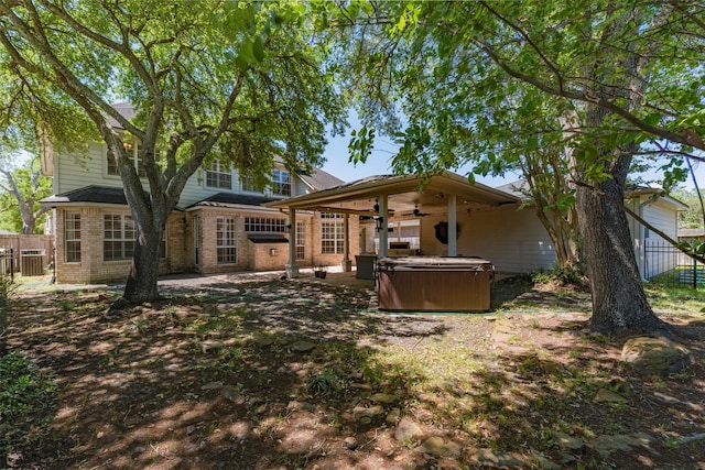 15122 Windsdowne Ln, Cypress, TX 77429 - rear view of house with a hot tub, a ceiling fan, brick siding, and a patio