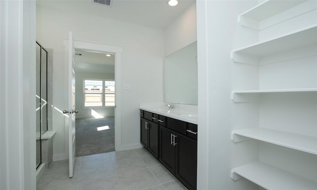 full bathroom with tile patterned flooring, visible vents, a sink, an enclosed shower, and double vanity