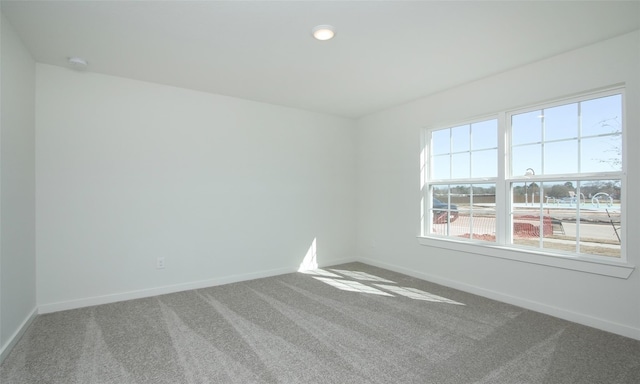 carpeted spare room with baseboards