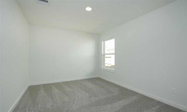 carpeted spare room featuring recessed lighting, visible vents, and baseboards