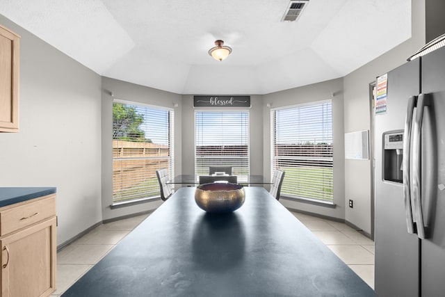 dining room with a raised ceiling, visible vents, baseboards, and light tile patterned floors