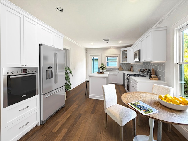 636 Pizer St, Houston, TX 77009 - kitchen with appliances with stainless steel finishes, a sink, light countertops, dark wood-style flooring, and white cabinets