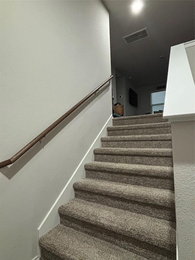 stairs with baseboards and visible vents