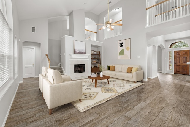living room featuring arched walkways, a ceiling fan, and wood finished floors