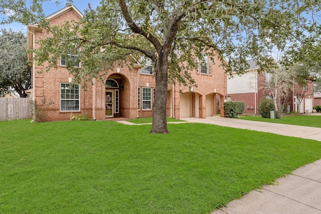 view of front of home with a front yard, brick siding, driveway, and fence