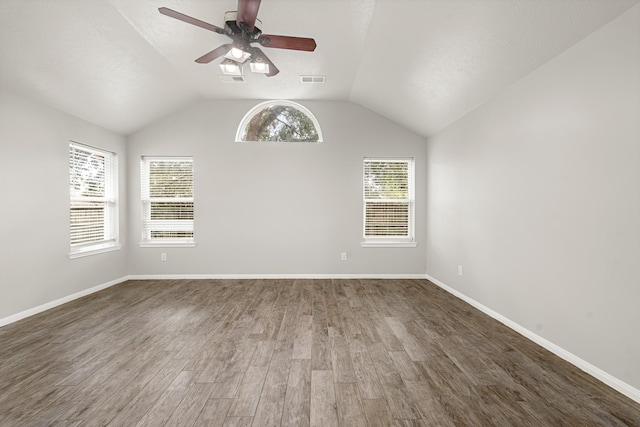unfurnished room with wood finished floors, ceiling fan, baseboards, and lofted ceiling