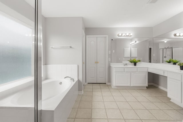bathroom with tile patterned floors, vanity, a garden tub, and a stall shower