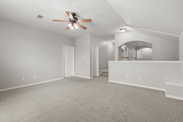 spare room featuring light colored carpet, visible vents, baseboards, and a ceiling fan