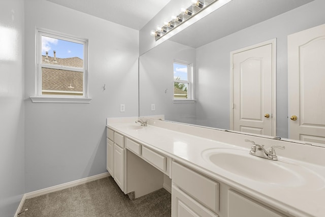 full bath featuring double vanity, baseboards, and a sink