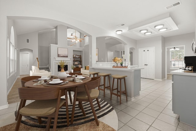 dining space featuring arched walkways, an inviting chandelier, light tile patterned flooring, and visible vents