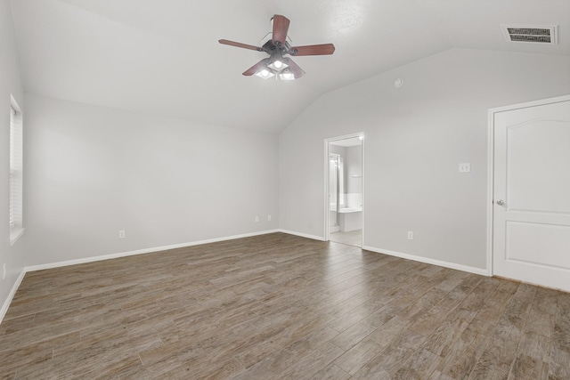 spare room featuring visible vents, baseboards, ceiling fan, vaulted ceiling, and wood finished floors