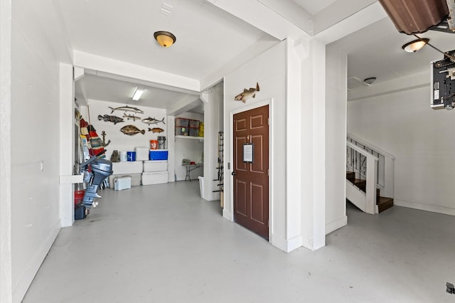 entrance foyer featuring stairs, finished concrete floors, and baseboards