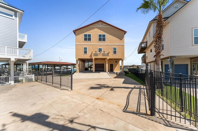 view of front of house with concrete driveway, a carport, and fence