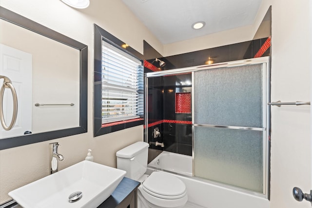 full bathroom with enclosed tub / shower combo, toilet, and vanity