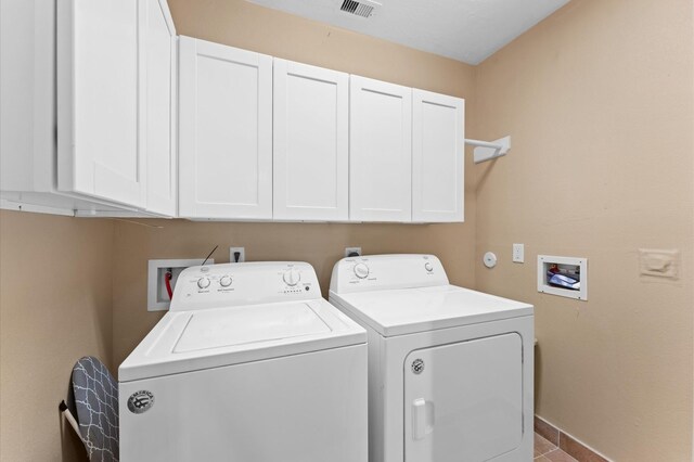washroom featuring cabinet space, washing machine and clothes dryer, and baseboards