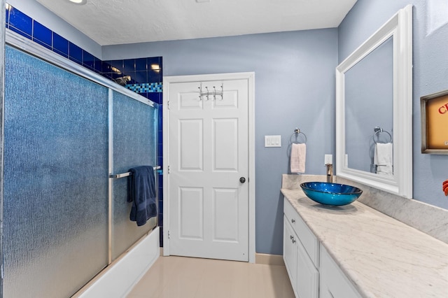 bathroom with bath / shower combo with glass door and vanity