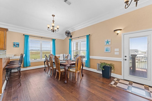 dining space with a chandelier, crown molding, dark wood-style flooring, and baseboards