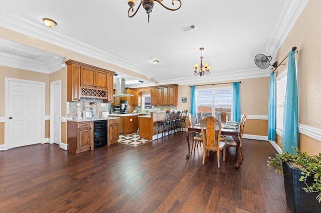dining room with a chandelier, beverage cooler, dark wood-style floors, crown molding, and baseboards