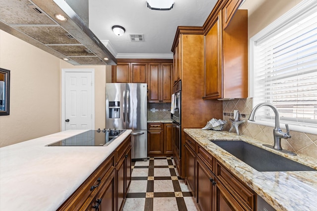 kitchen featuring stainless steel refrigerator with ice dispenser, a sink, black electric stovetop, range hood, and inlaid floor details
