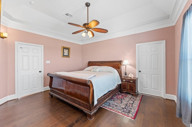 bedroom with a raised ceiling, wood finished floors, baseboards, crown molding, and ceiling fan