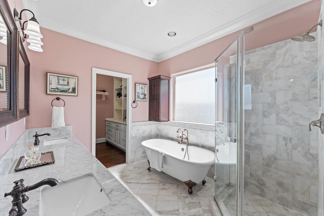 full bathroom with a stall shower, ornamental molding, a freestanding tub, double vanity, and a spacious closet