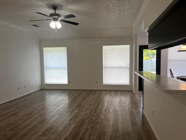 4027 N Fm 565th Rd, Mont Belvieu, TX 77523 - unfurnished living room featuring crown molding, wood finished floors, baseboards, ceiling fan, and a textured ceiling