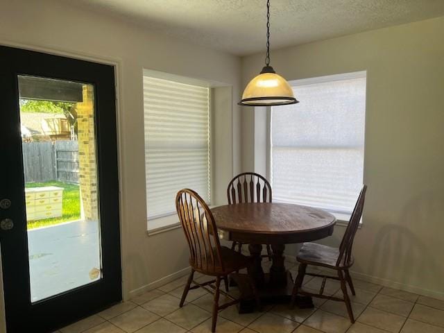 4027 N Fm 565th Rd, Mont Belvieu, TX 77523 - dining space with light tile patterned flooring, baseboards, and a textured ceiling
