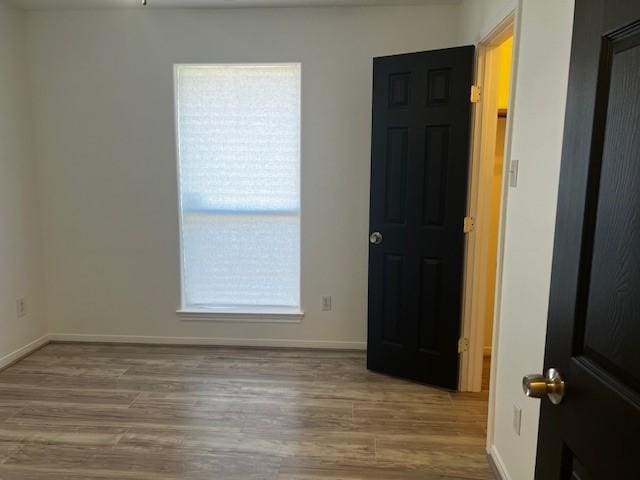 4027 N Fm 565th Rd, Mont Belvieu, TX 77523 - empty room with wood finished floors and baseboards