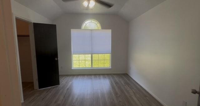 4027 N Fm 565th Rd, Mont Belvieu, TX 77523 - unfurnished bedroom with wood finished floors, vaulted ceiling, baseboards, and ceiling fan