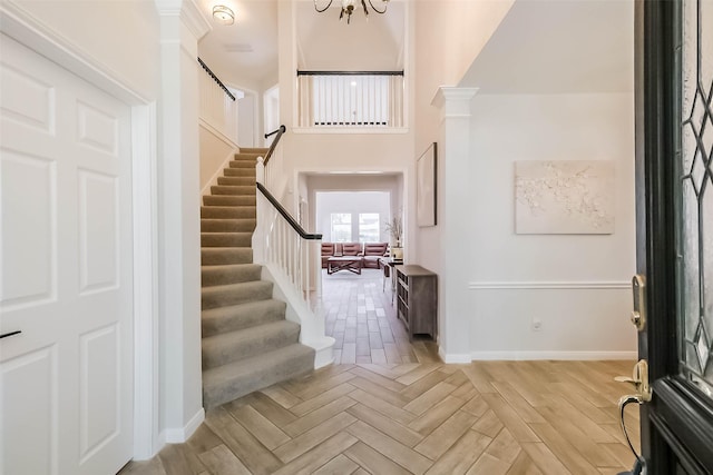 7015 Timber Edge Ln, Humble, TX 77346 - entrance foyer with stairs, baseboards, decorative columns, and a towering ceiling