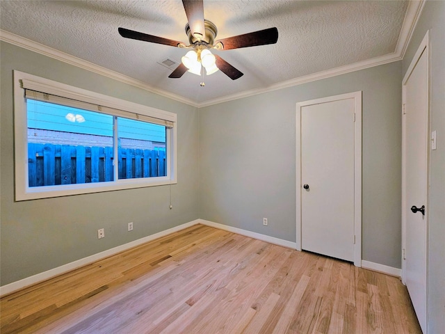 empty room with a ceiling fan, a textured ceiling, visible vents, and light wood finished floors