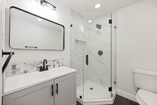 3806 Zephyr St, Houston, TX 77021 - bathroom featuring tasteful backsplash, vanity, baseboards, a marble finish shower, and toilet