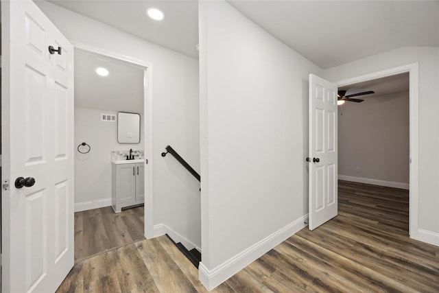 3806 Zephyr St, Houston, TX 77021 - corridor with baseboards, an upstairs landing, visible vents, a sink, and wood finished floors