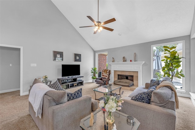 carpeted living room with high vaulted ceiling, a ceiling fan, baseboards, and a tiled fireplace