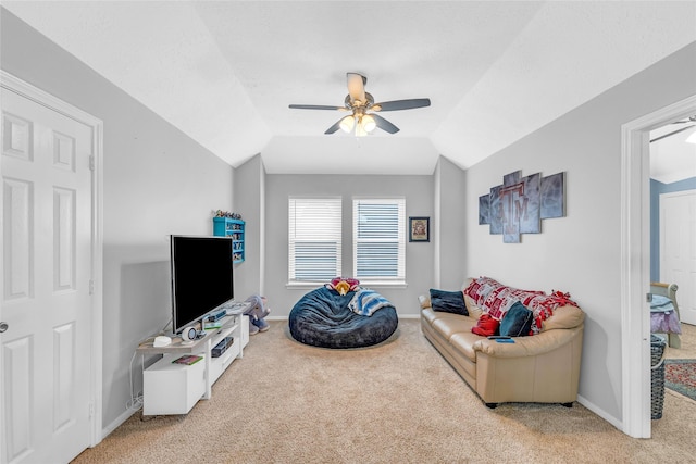 carpeted living room with a ceiling fan, baseboards, and vaulted ceiling