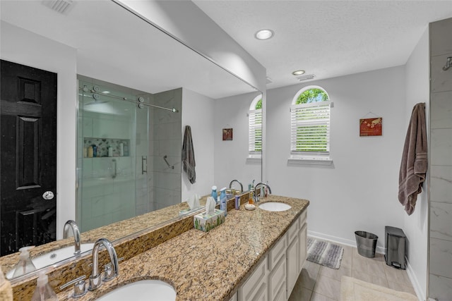 full bath with a stall shower, baseboards, double vanity, and recessed lighting