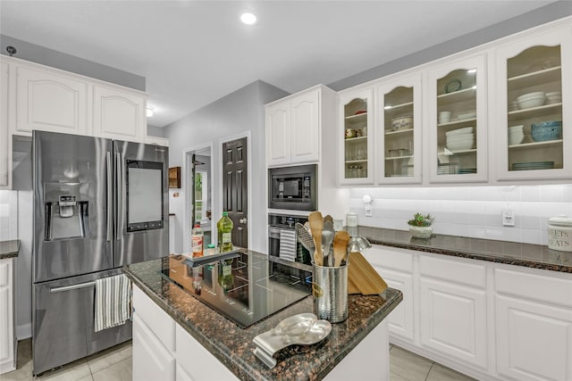 kitchen featuring stainless steel appliances, dark stone countertops, decorative backsplash, glass insert cabinets, and recessed lighting