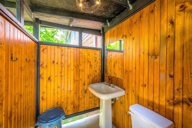 half bathroom with wooden walls and toilet