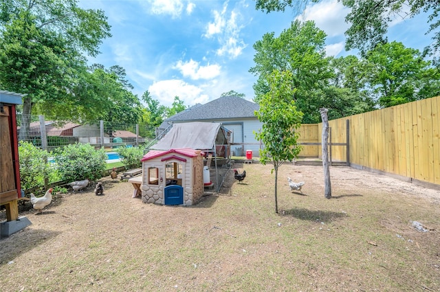 view of yard with exterior structure, an outdoor structure, and a fenced backyard