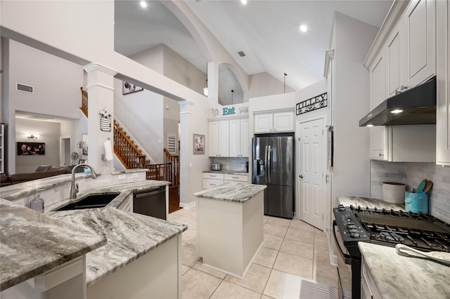 kitchen featuring a sink, stainless steel fridge with ice dispenser, black gas range oven, dishwashing machine, and under cabinet range hood