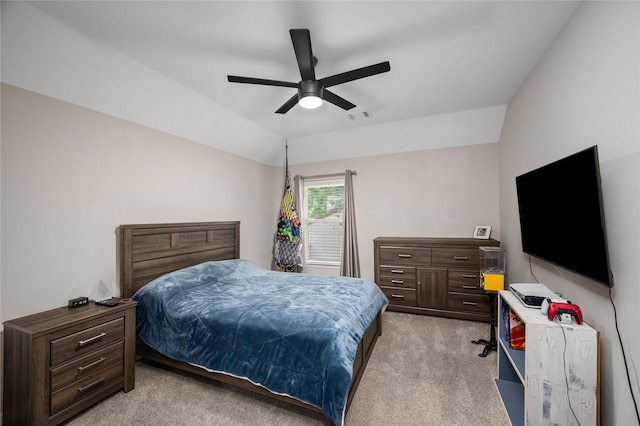 bedroom featuring a ceiling fan, visible vents, light carpet, and lofted ceiling