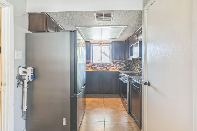 kitchen featuring visible vents, a sink, stainless steel appliances, backsplash, and light tile patterned flooring