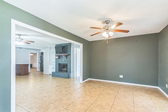unfurnished living room featuring light tile patterned floors, a brick fireplace, a textured ceiling, and a ceiling fan