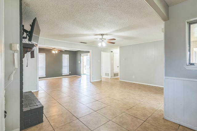 unfurnished living room featuring a textured ceiling, light tile patterned floors, a ceiling fan, and visible vents