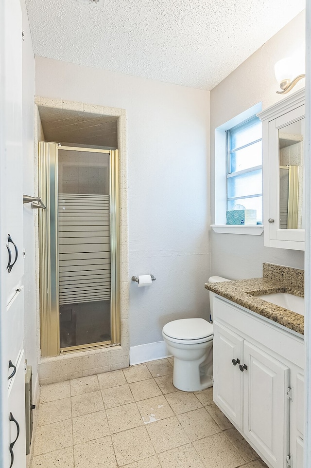 full bath featuring toilet, a textured ceiling, a stall shower, and vanity