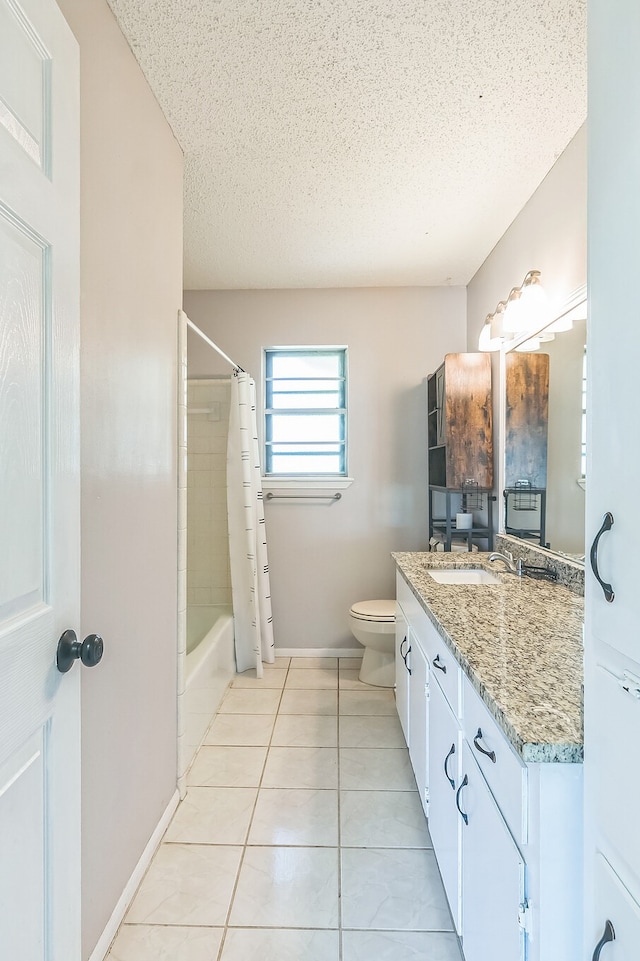 full bathroom featuring a textured ceiling, vanity, tile patterned flooring, toilet, and baseboards