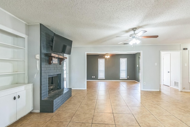 unfurnished living room with a textured ceiling, a ceiling fan, visible vents, a brick fireplace, and built in shelves